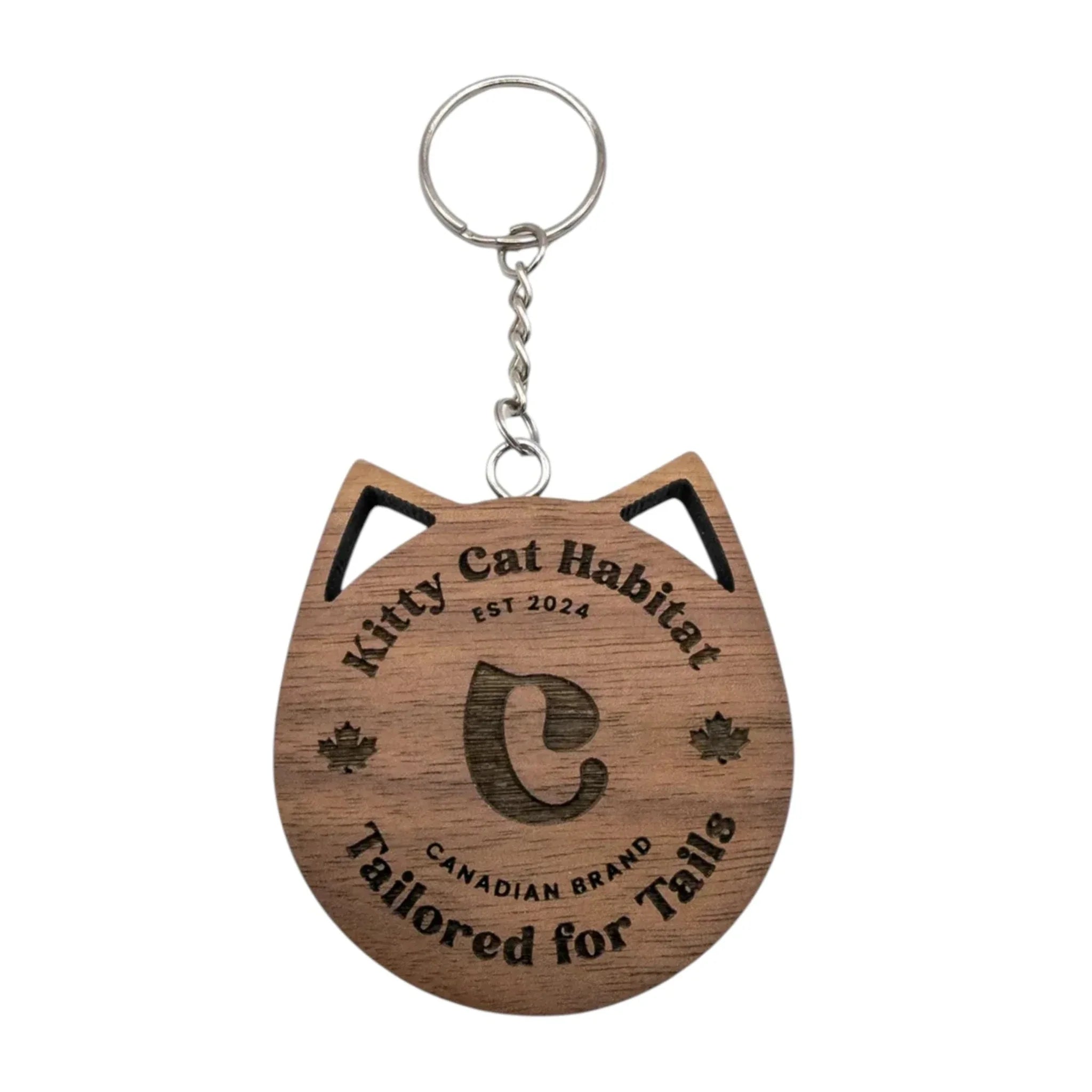 Walnut wooden cat head keychain with Kitty Cat Habitat logo engraving on a light background.