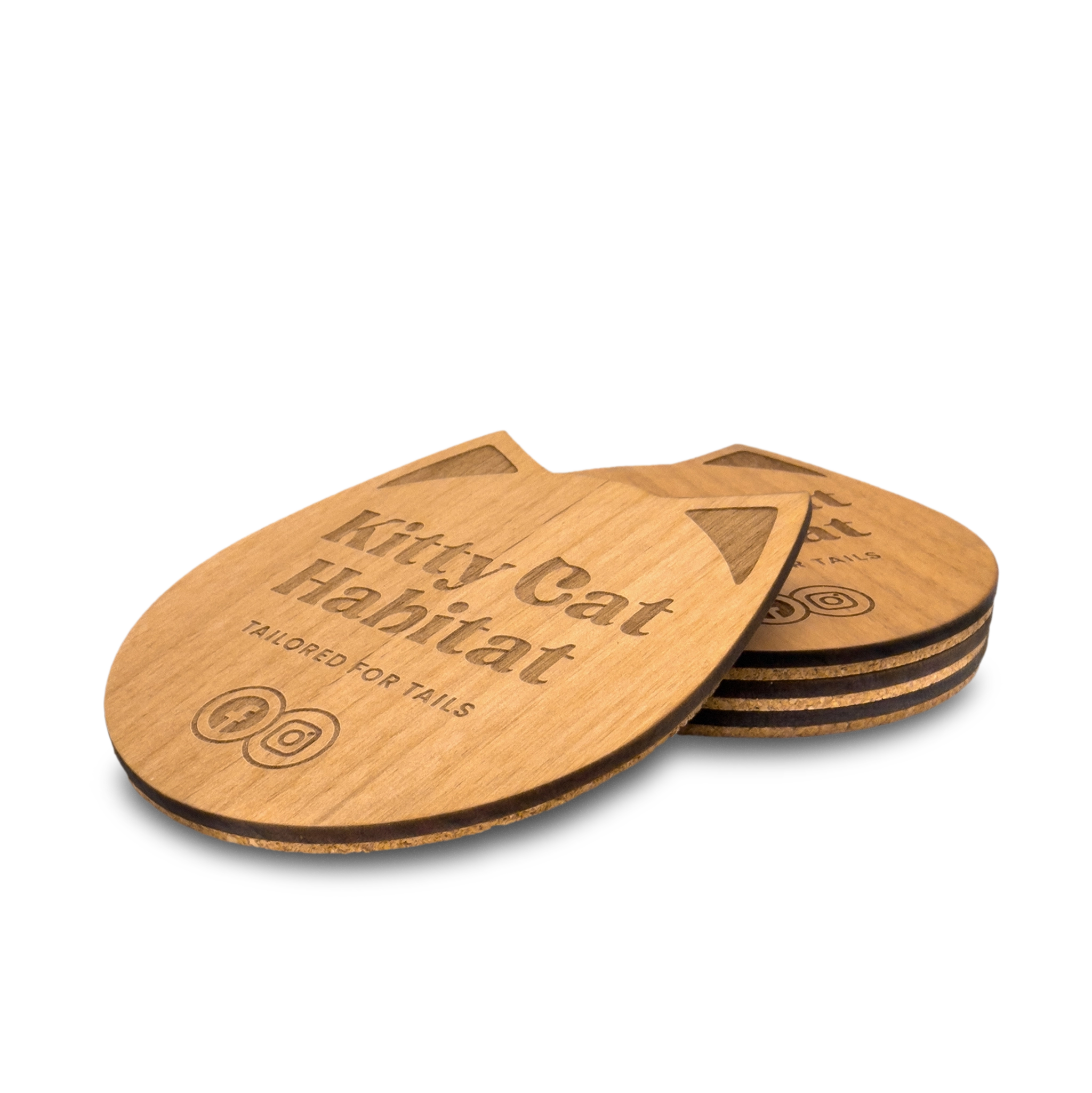 Small stack of wooden cat head drink coasters viewed from the side on a light background.
